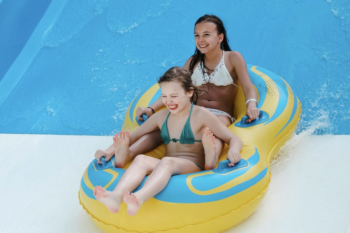 two little girls on tube on water slide at aquapar 2022 11 14 03 07 17 utc min scaled Water slide rental | Orlando FL